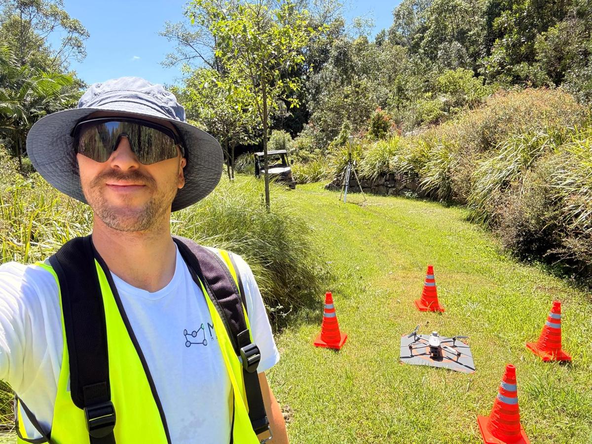 Jonathan on site in a hi-vis vest beside a ground control target