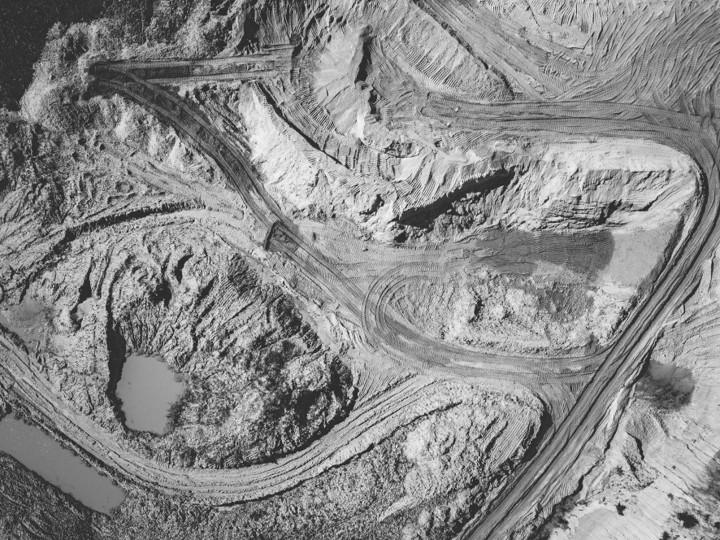 Black-and-white aerial view of a quarry with haul roads